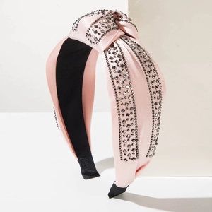 Detail of pink satin headband with three rows of square rhinestones and knotted center design