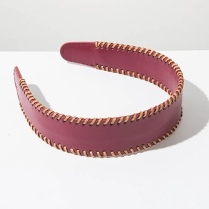 Detailed macro view of the retro wine red leather headband with brown braided edge textures