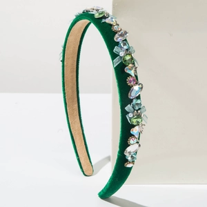 Detail of green velvet headband featuring colorful crystals and a light blue mesh bow