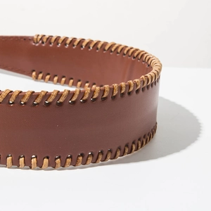 Macro detail of brown leather headband with beige whipstitch edges and premium texture