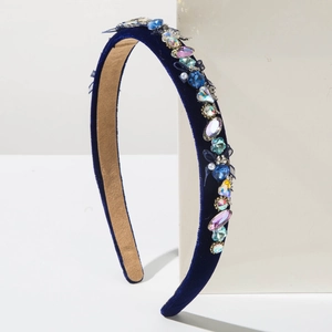 Detailed close-up of dark blue velvet headband with colorful rhinestones and pearls