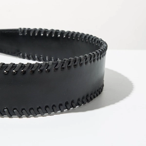 Detailed macro view of black leather headband with intricate cross-stitch woven edge details