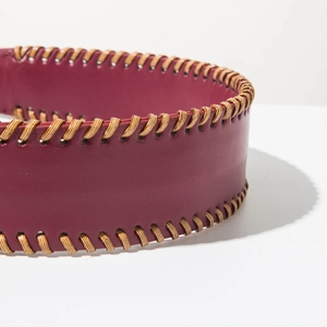 Detail view of burgundy leather wide headband with artisanal beige braided cord edge trim