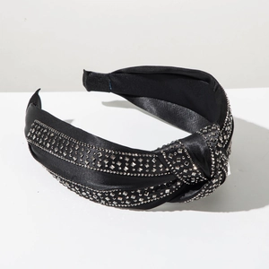 Macro detail of black satin knotted headband embellished with sparkling silver rhinestones