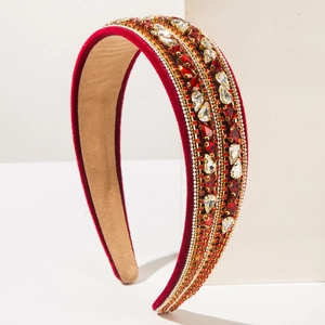 Gros plan du serre-tête en velours rouge orné de strass brillants et perles de cristal