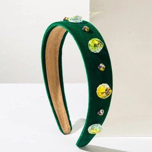 Detail of baroque velvet headband with colorful rhinestones on a white display block