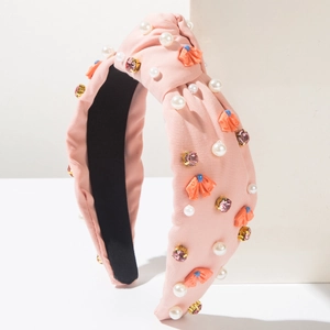 Dettaglio fascia rosa annodata con perle bianche, cristalli e piccoli fiori arancio