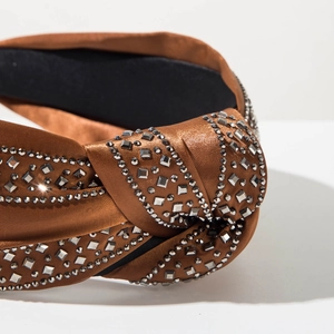 Close-up of brown satin headband with sparkling silver rhinestones and knot detail