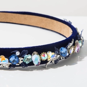 Detail of luxury royal blue velvet headband featuring crystal clusters and mesh bow
