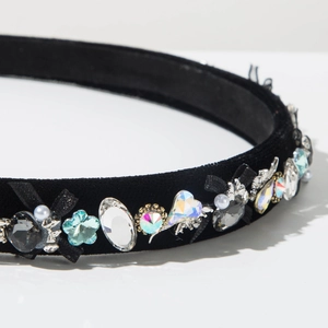 Close-up of velvet headband with crystal gems, pearls and small ribbon bows