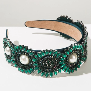 Detailed view of Baroque emerald green crystals and white pearls on headband