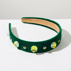 Detail of dark green velvet headband with colorful rhinestones and shell crystal design