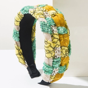 Bohemian braided headband with green sequins, pearls, and crystals on geometric prop