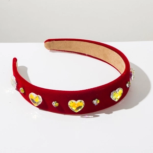 Macro detail of red velvet headband featuring yellow heart crystals and colorful rhinestones