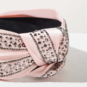 Macro detail of pink satin headband featuring crystal rhinestones and textured knot