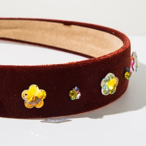 Detailed macro view of baroque velvet headband featuring colorful crystals and gemstones
