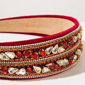 Détail de luxe d'un serre-tête en velours bordeaux avec strass étincelants et perles