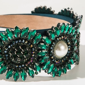Detail of dark green baroque headband with emerald crystals and large white pearl center