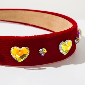 Close-up of baroque deep red velvet headband with heart crystals and rhinestones