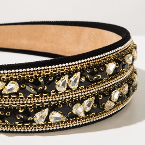 Détail macro du serre-tête baroque en velours avec chaînes dorées et cristaux brillants