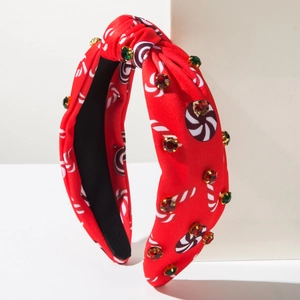 Détail d'un serre-tête de Noël rouge avec imprimé sucre d'orge et strass brillants colorés
