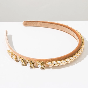 Detail of champagne velvet headband with crystal leaves and golden pearl bee ornaments