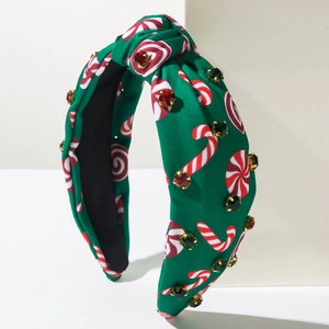 Détail d'un serre-tête de Noël vert avec motifs de cannes de sucre et strass étincelants