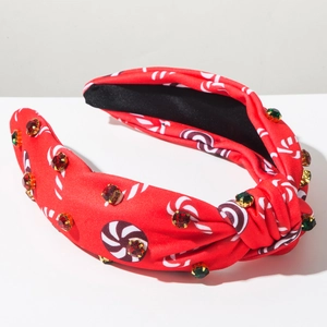 Gros plan du serre-tête de Noël rouge avec motifs sucres d'orge et strass colorés