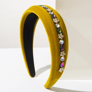 Detailed macro view of mustard yellow velvet headband with gold floral rhinestones