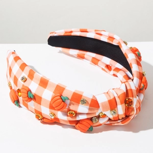 Close-up of orange plaid headband with knotted pumpkin accents and sparkling rhinestones