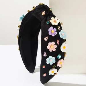 Détail d'un serre-tête noué noir avec fleurs en résine colorées et strass étincelants