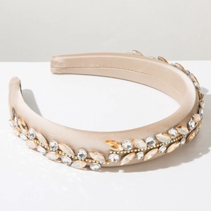 Close-up of champagne satin headband featuring intricate amber and clear gemstone patterns