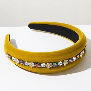 Detailed shot of velvet padded headband with mustard yellow fabric and rhinestone flowers