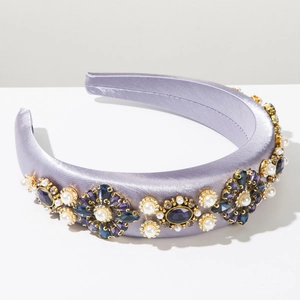 Détail d'un serre-tête baroque en satin violet avec cristaux et perles blanches