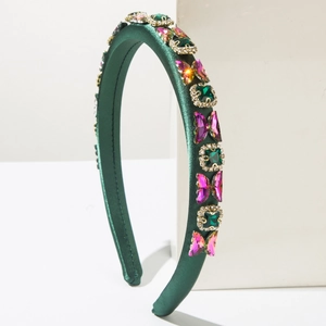 Detail of green satin headband with emerald crystals and purple butterfly stones