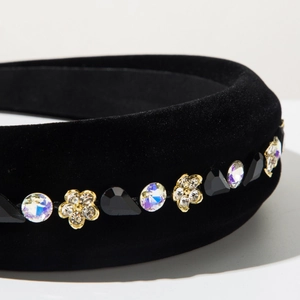 Macro detail of black velvet headband with AB rhinestones and gold flower charms