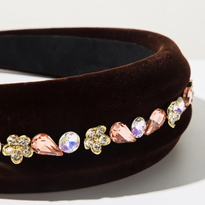 Macro detail of velvet headband featuring colorful crystals and metallic flower ornaments