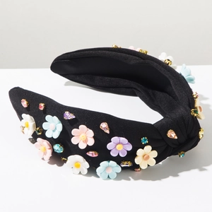 Détail d'un serre-tête baroque avec fleurs en résine colorées et strass sur tissu noir