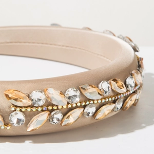 Macro shot of sparkling champagne satin padded headband with amber crystals and rhinestones