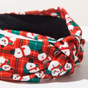 Detail van rood en groen geruite kersthoofdband met sneeuwpop-print en knoopontwerp