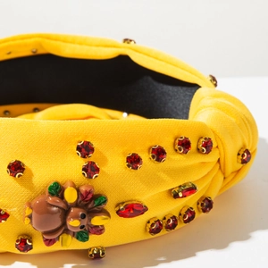 Detail of yellow Thanksgiving headband with red rhinestones and turkey resin ornament