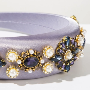 Détail d'un serre-tête en satin lavande orné de pierres violettes et de perles blanches