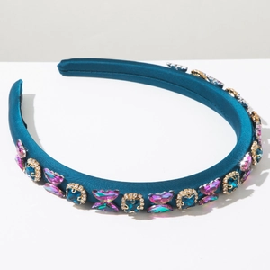 Macro shot of peacock blue satin headband with crystal butterfly and rhinestone details