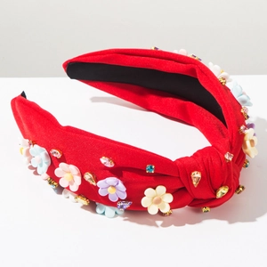 Détail du serre-tête baroque rouge noué avec fleurs en résine et strass colorés brillants