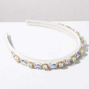 Close-up of white padded headband with sparkling square crystal rhinestone embellishments