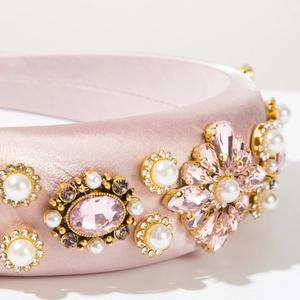 Vue détaillée d'un serre-tête en satin rose avec cristaux, perles et strass