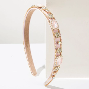 Close-up of pink baroque headband with rhinestones and gems on a white stand