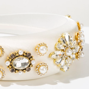 Détail du serre-tête en satin blanc avec cristaux floraux, strass et perles de culture