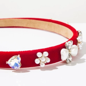 Detail of red velvet headband with pearls, crystals, and heart-shaped charms