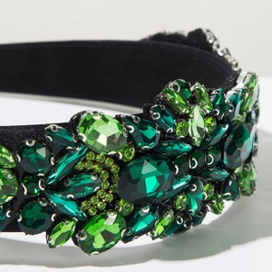 Close-up of luxury green crystals and sparkling gems on a black velvet headband
